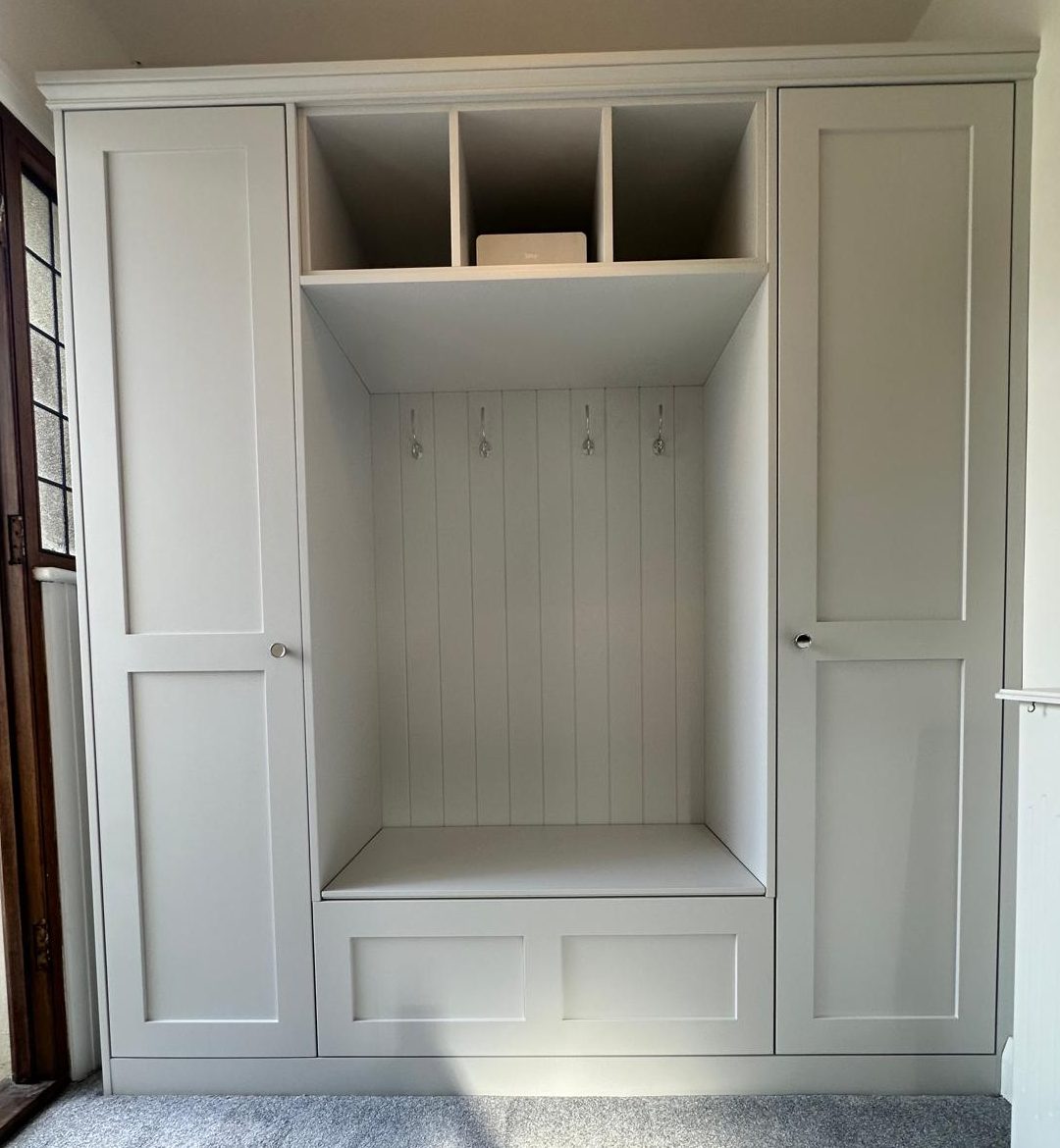 Bespoke storage with hidden shoe space fitted with coat hooks in Kent